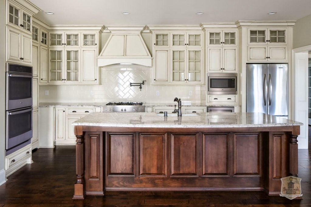 20 Types of Kitchen Cabinets 5 Rich walnut raised panel kitchen cabinets with granite countertops and decorative crown molding.